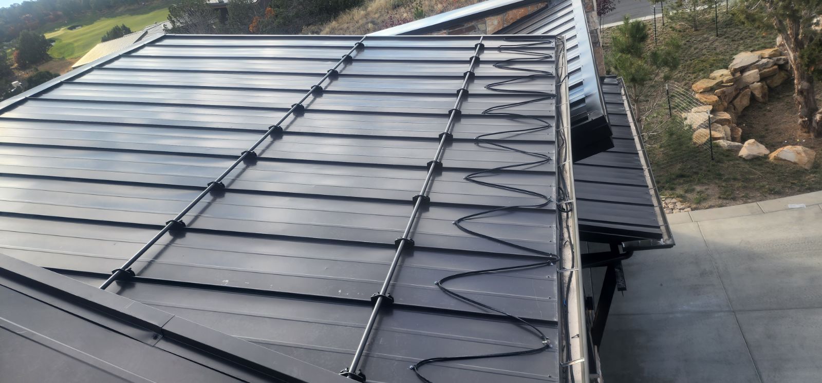 Metal roof with zigzag-patterned heating cable installation.